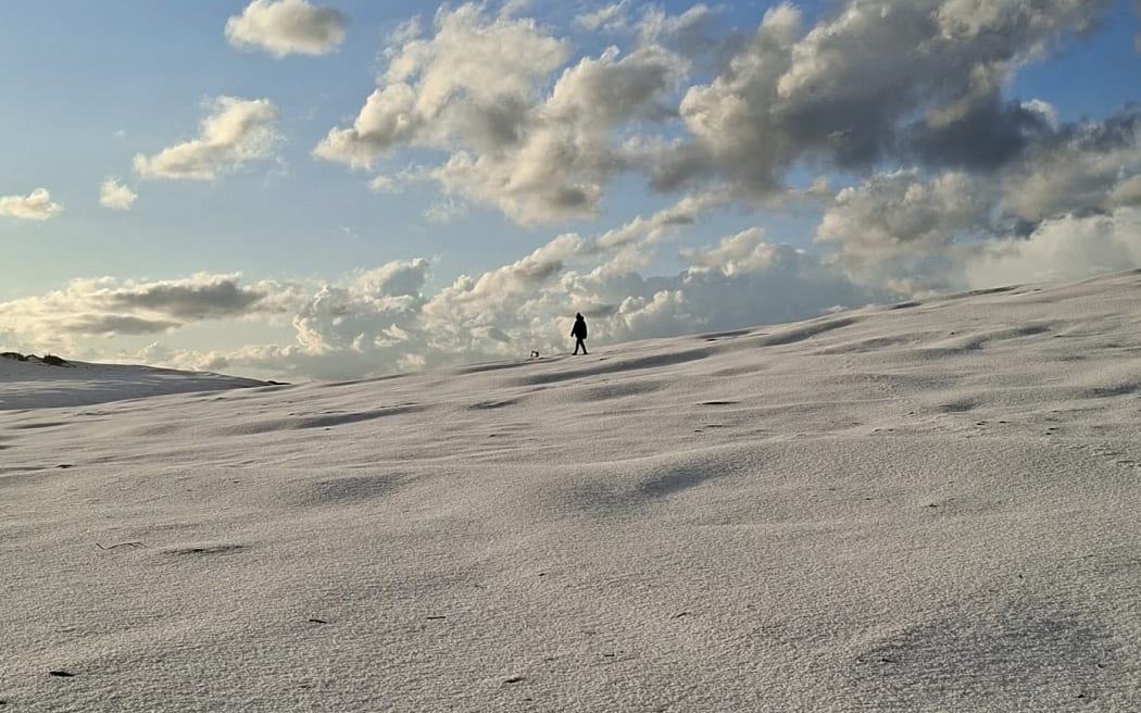 Hail covering a Northland beach at Pouto Peninsula, New Zealand, winter camping adventure.